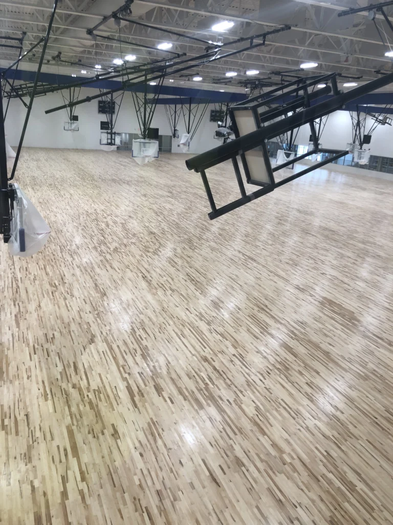Shot from the rafters of the basketball courts in fargo sports center. Backboards and hoops still have plastic bags and no lines have been painted on the hardwood floor